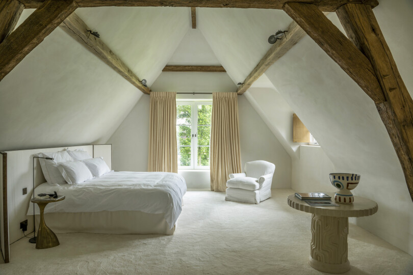 Ambiance épurée et feutrée dans la chambre master aux murs mansardés.